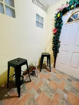 two tables and a door with a christmas wreath at Habitación privada en villa familiar en La Libertad in Zaragoza