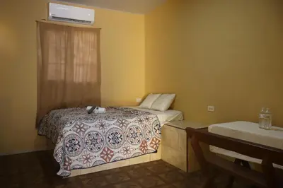 a hotel room with a bed and a window at Habitacion Costabay in El Zapote