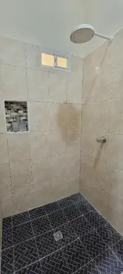 a bathroom with a shower with a tiled floor at Habitacion Costabay in El Zapote
