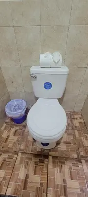 a white toilet in a bathroom with a tile floor at Habitacion Costabay in El Zapote