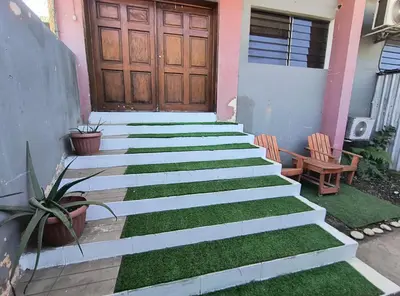 a set of stairs leading to a house with grass at Apartment in Playa Las Flores La Libertad in La Libertad