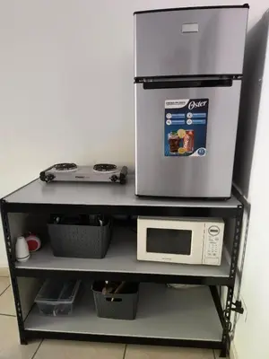 a refrigerator sitting on top of a shelf with a microwave at Apartment in Playa Las Flores La Libertad in La Libertad