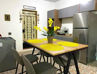 a kitchen with a table with yellow plates and a refrigerator at Casa Acogedora