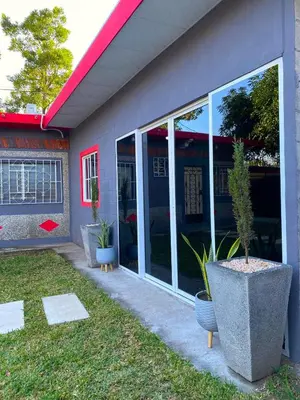 a house with large glass windows and a potted plant at Casa Acogedora