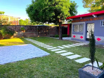 a garden with a tree and a house at Casa Acogedora