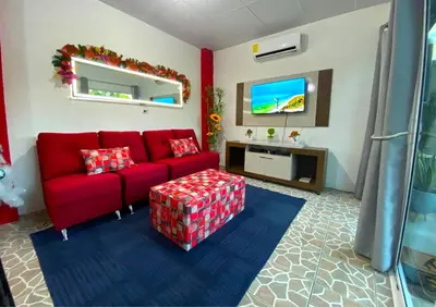 a living room with a red couch and a tv at Casa Acogedora