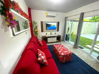 a living room with a red couch and a tv at Casa Acogedora