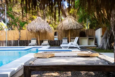 a swimming pool with chairs and umbrellas next to a swimming pool at Villa Con Piscina, Playa, Jacuzzi, Kayaks in Conchagua