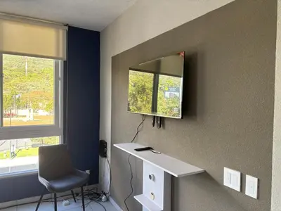 a room with a mirror and a chair and a desk at Apartment in Colonia Escalón with pool and gym in San Salvador