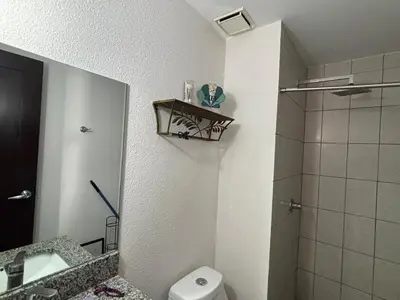 a bathroom with a toilet and a sink and a shower at Apartment in Colonia Escalón with pool and gym in San Salvador