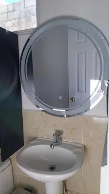 a bathroom with a sink and a mirror at The small house in Ahuachapán