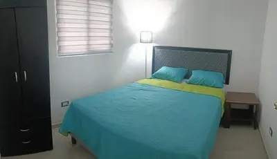 a bedroom with a bed with blue and yellow sheets at The small house in Ahuachapán