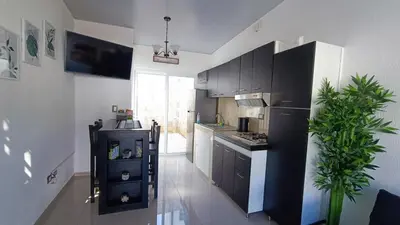 a kitchen with black cabinets and a black refrigerator at The small house in Ahuachapán