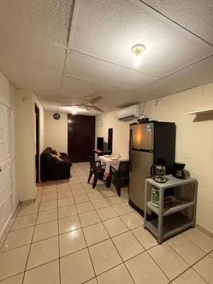 a kitchen and living room with a refrigerator and a table at El Pibe