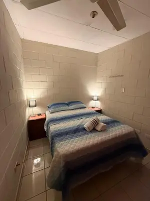 a bedroom with a bed with two pillows on it at El Pibe
