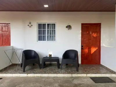 two chairs and a table in front of a house at El Sunzal Azul in El Sunzal