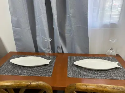 a wooden table with two plates and two wine glasses at El Sunzal Azul in El Sunzal