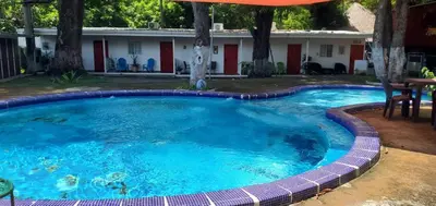 a large swimming pool with an umbrella in front of a house at El Sunzal Azul in El Sunzal