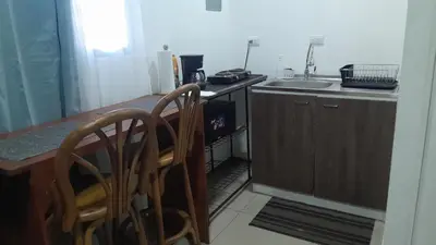 a kitchen with a table and two chairs and a sink at El Sunzal Azul in El Sunzal
