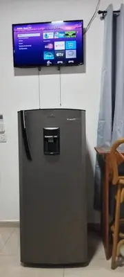 a television sitting on top of a refrigerator at El Sunzal Azul in El Sunzal