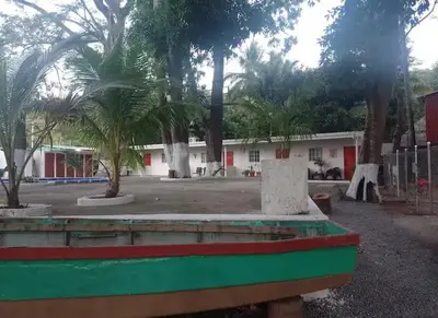 a park with palm trees in front of a building at El Sunzal Azul in El Sunzal