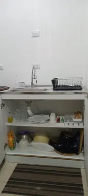 a kitchen cabinet with a sink and some dishes at El Sunzal Azul in El Sunzal