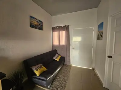 a living room with a black couch and a door at Casa Márquez in San Miguel