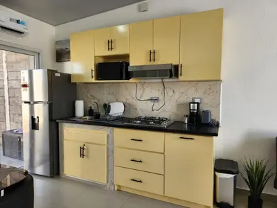 a kitchen with yellow cabinets and a refrigerator at Casa Márquez in San Miguel