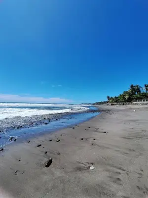 a beach with footprints in the sand and the ocean at Surfcity - AC - WiFi - Coastal Paradise SV in La Libertad