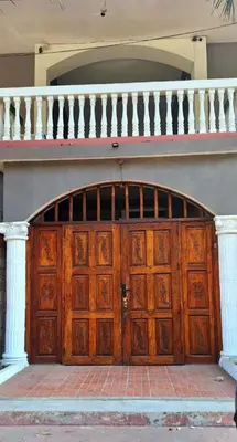 a large wooden door of a building with a staircase at Surfcity - AC - WiFi - Coastal Paradise SV in La Libertad
