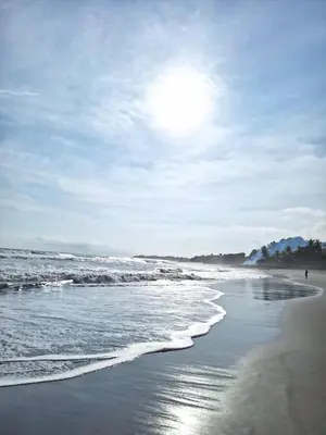 a beach with the sun shining on the water at Surfcity - AC - WiFi - Coastal Paradise SV in La Libertad