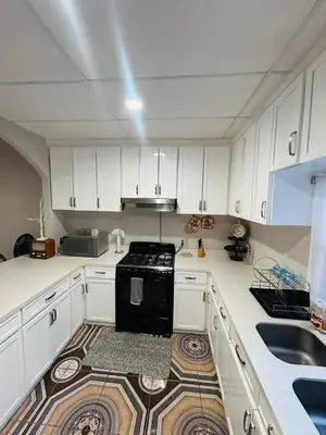a kitchen with white cabinets and a black stove at Agradable vivienda vacacional in Suchitoto
