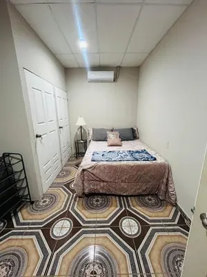 a bedroom with a bed and a tiled floor at Agradable vivienda vacacional in Suchitoto