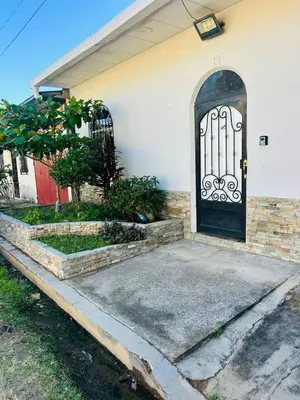 a house with a black door and a driveway at Agradable vivienda vacacional in Suchitoto