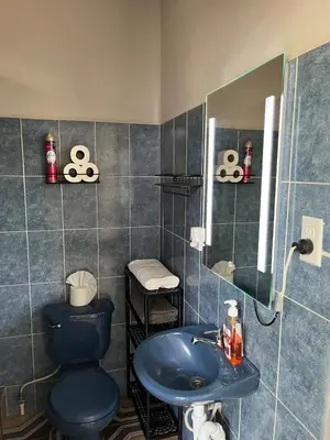 a bathroom with a blue toilet and a sink at Pleasant Vacation Home in Suchitoto