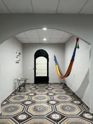 a hallway with a tile floor and a black door at Pleasant Vacation Home in Suchitoto