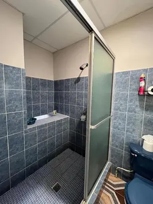 a bathroom with a shower and a blue toilet at Pleasant Vacation Home in Suchitoto