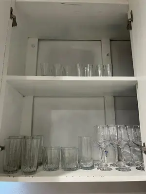 a shelf filled with empty glasses on it at Pleasant Vacation Home in Suchitoto