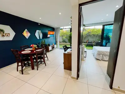 a dining room with a table and a bedroom at Apto con 2BR Jardin y Parking Gratis Col Escalon in San Salvador