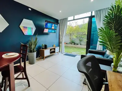 a living room with blue walls and a table and chairs at Apto con 2BR Jardin y Parking Gratis Col Escalon in San Salvador