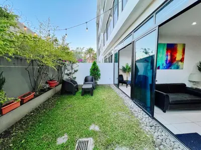 an internal courtyard of a house with grass and chairs at Apto con 2BR Jardin y Parking Gratis Col Escalon in San Salvador