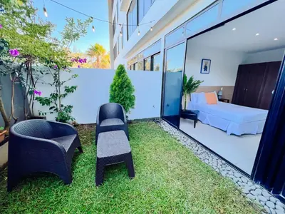 a room with a garden with chairs and a bed at Apto con 2BR Jardin y Parking Gratis Col Escalon in San Salvador