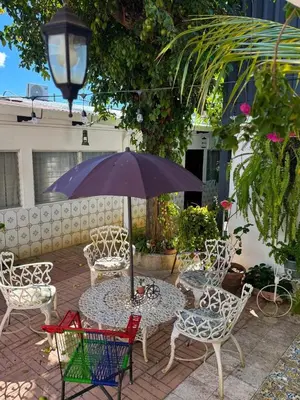 a table and chairs with an umbrella on a patio at Neska Polita Hostel in Juayúa