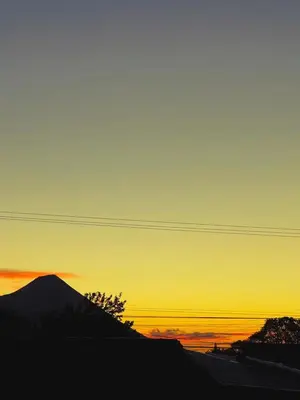 a sunset with a mountain in the background at Neska Polita Hostel in Juayúa