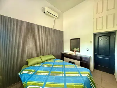 a bedroom with a bed and a sink and a mirror at Beautiful and Remodeled House Metropolis S Gabriel in Nejapa