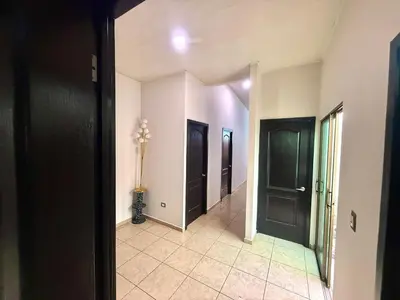 a hallway with two black doors and a tile floor at Beautiful and Remodeled House Metropolis S Gabriel in Nejapa