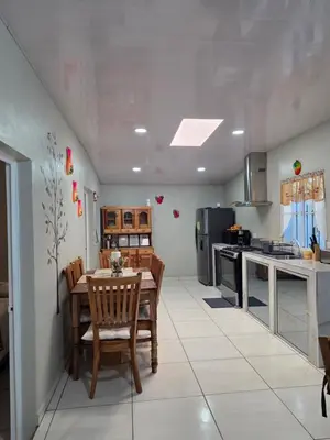 a kitchen with a table and chairs in a room at La Casita Cruz in Caluco
