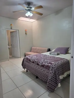 a bedroom with a bed and a ceiling fan at La Casita Cruz in Caluco