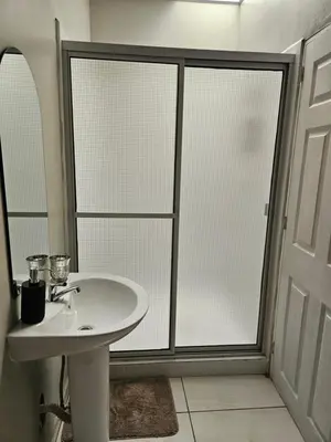 a bathroom with a white sink and a shower at La Casita Cruz in Caluco