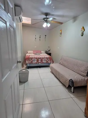 a bedroom with a bed and a ceiling fan at La Casita Cruz in Caluco